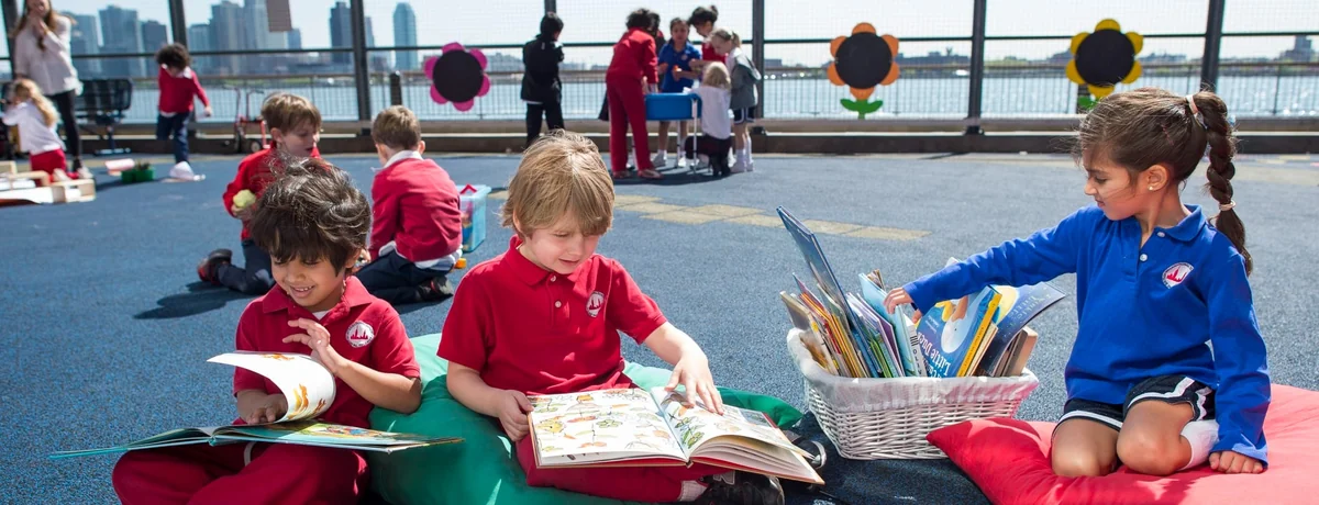 BISNY Early Years children reading together on the terrace